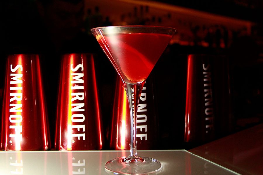 Frisch gemixter Cocktail im Martiniglas vor roten Barshakern
